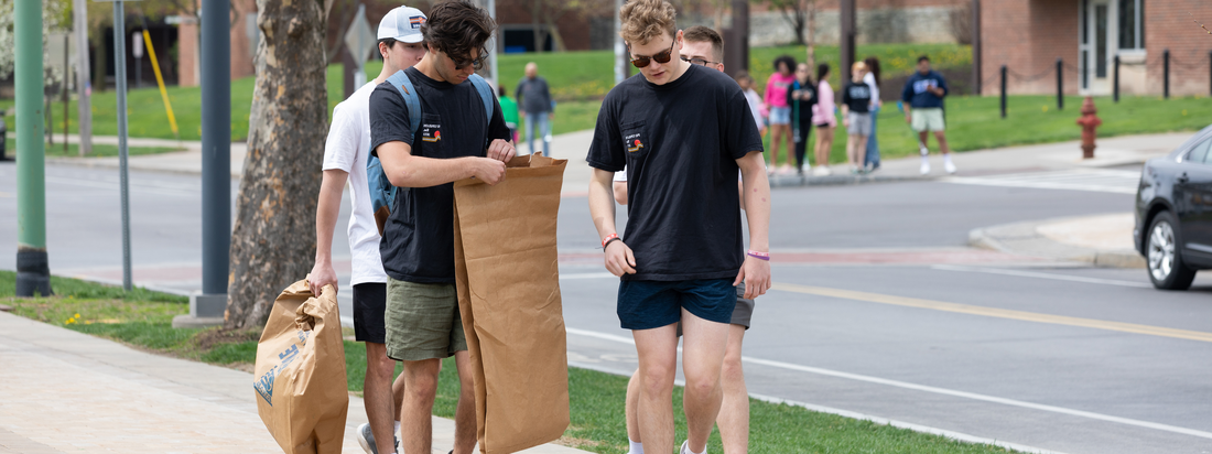 Students picking up trash on the street.